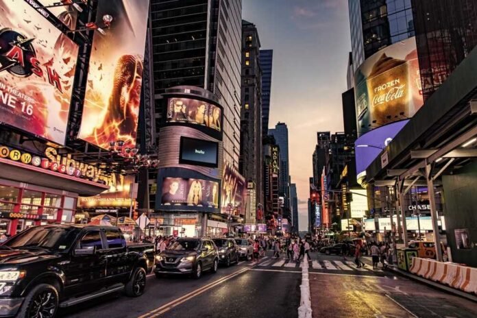 shutterstock_2460739543.jpg Busy street scene in Times Square with cars and pedestrians