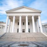Front view of a historic government building with white columns and steps