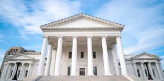 Front view of a historic government building with white columns and steps