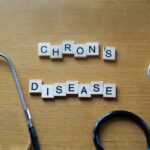 Wooden letter blocks spelling 'Crohn's Disease' next to a stethoscope