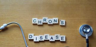 Wooden letter blocks spelling 'Crohn's Disease' next to a stethoscope