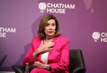 A woman in a pink suit speaking at a conference