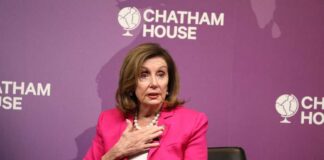 A woman in a pink suit speaking at a conference
