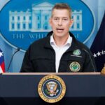 Government official speaking at a press conference in front of the White House
