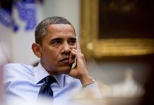 A thoughtful man resting his chin on his hand during a meeting