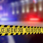 Mass Killing Site or Training Ground? MYSTERY Yellow police caution tape with the text 'POLICE LINE DO NOT CROSS' in a blurred background