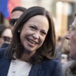A woman smiling while engaging in conversation at a public event