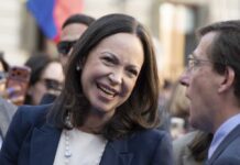 A woman smiling while engaging in conversation at a public event