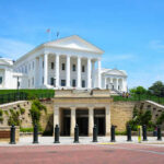 Historic government building with white columns and green lawn