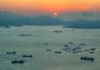 A scenic view of cargo ships on water during sunset