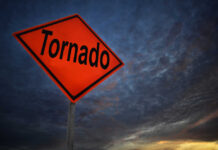 Tornado warning sign against a dramatic sky