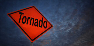Tornado warning sign against a dramatic sky