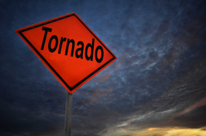 Tornado warning sign against a dramatic sky