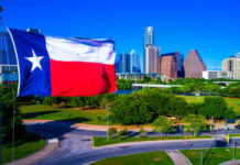 Texas flag waving in front of the Austin skyline