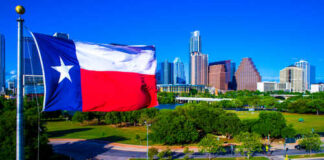 Texas flag waving in front of the Austin skyline
