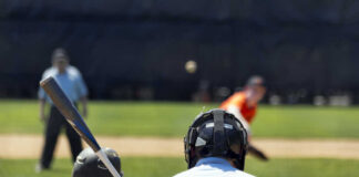 A young baseball player preparing to bat as a pitcher throws the ball