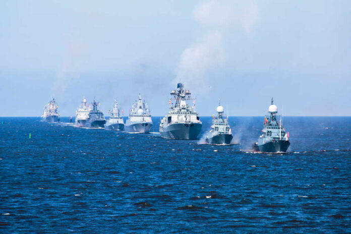 A fleet of warships sailing in formation on the ocean