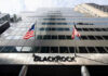 Modern skyscraper with BlackRock sign and American flags