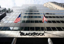 Modern skyscraper with BlackRock sign and American flags