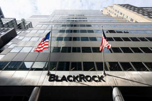 Modern skyscraper with BlackRock sign and American flags