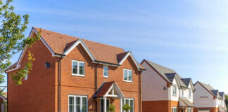 Red-brick suburban house in a sunny neighborhood.