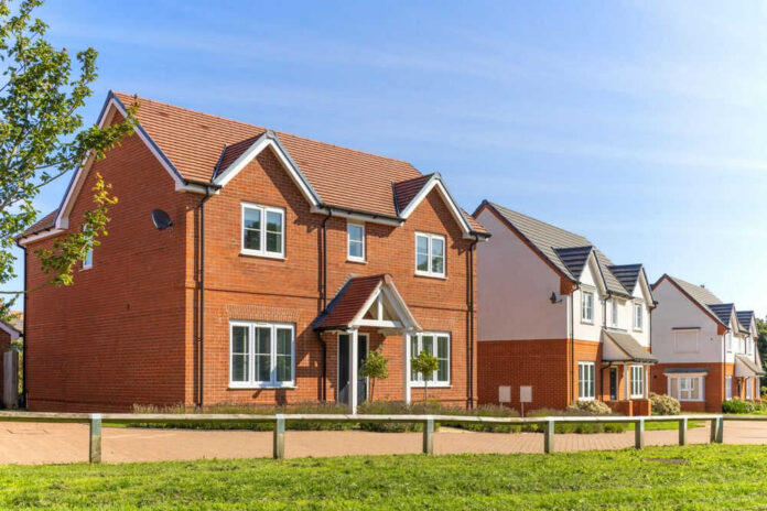 Red-brick suburban house in a sunny neighborhood.