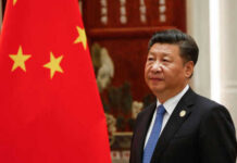 Person standing near a Chinese flag indoors