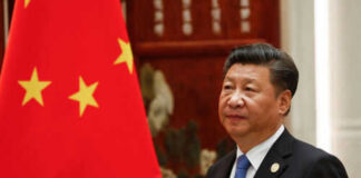 Person standing near a Chinese flag indoors
