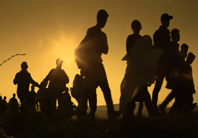 Silhouetted figures walking against a sunset backdrop