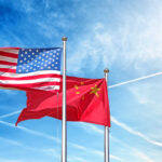 U.S.-China Summit: What’s Really at Stake? Flags of the United States and China waving against a blue sky