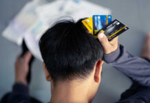 Person holding multiple credit cards while looking stressed