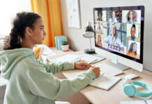 A young girl participating in a virtual meeting on a computer