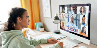 A young girl participating in a virtual meeting on a computer