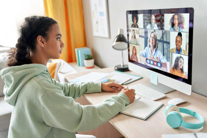 A young girl participating in a virtual meeting on a computer