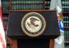 Podium with the Department of Justice seal and American flag in the background