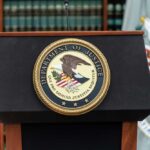 Explosive DOJ Probe: Did E. Jean Carroll Lie? Podium with the Department of Justice seal and American flag in the background