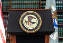 Podium with the Department of Justice seal and American flag in the background