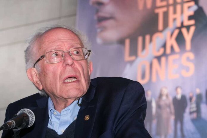 An elderly man speaking at a microphone during an event