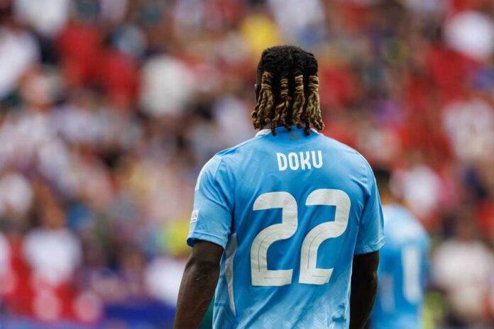 Soccer player wearing a blue jersey with the name Doku and number 22, facing away from the camera