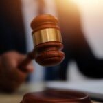 Judge’s Bold Move Divides: Cameras Stay In! A gavel being struck on a desk in a courtroom setting
