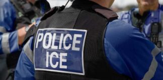Close-up of a police officer's vest with 'POLICE ICE' insignia