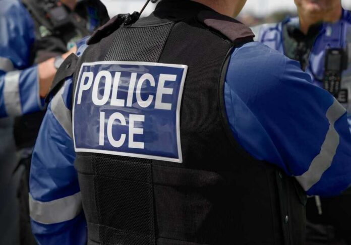 Close-up of a police officer's vest with 'POLICE ICE' insignia