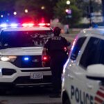 Police officers responding to an incident at night with flashing lights
