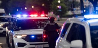 Police officers responding to an incident at night with flashing lights