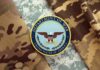 Department of War insignia on camouflage fabric