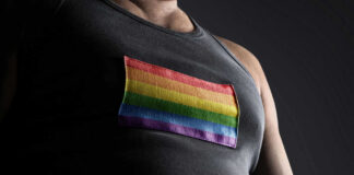 Person wearing shirt with rainbow flag patch