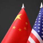 Chinese and American flags against dark background