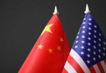 Chinese and American flags against dark background