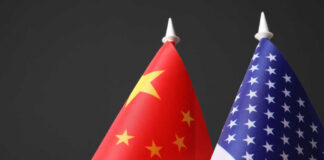Chinese and American flags against dark background