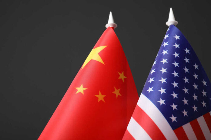 Chinese and American flags against dark background